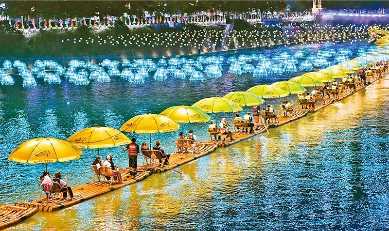 游客在湖北省宣恩县贡水河上乘坐竹筏欣赏夜色