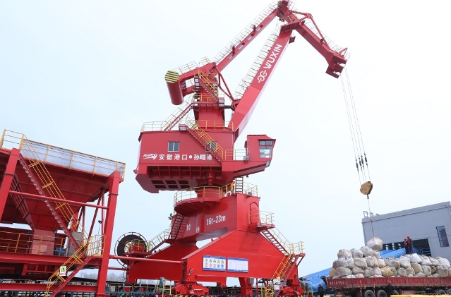 现场起重机、多用途门机、移动式装船机屹立在浍河岸边正在吊运货物